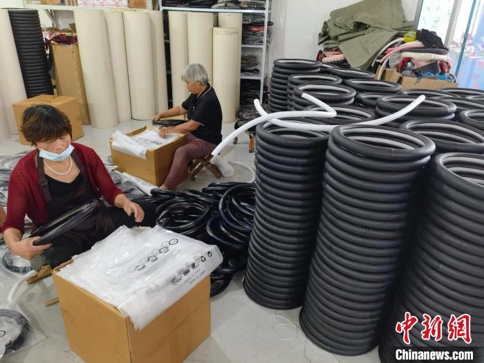 圖為村民在汽車(chē)飾品企業(yè)生產(chǎn)車(chē)間中工作?！巫雍?攝