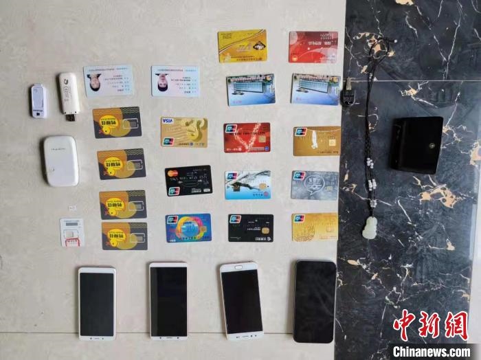 資料圖為果洛藏族自治州公安民警查扣的作案手機和涉案銀行卡?！‖斍呖h公安局供圖