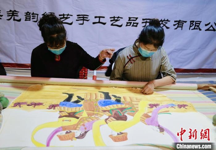 圖為皮繡藝人在市集上“秀”指尖技藝?！●R銘言 攝