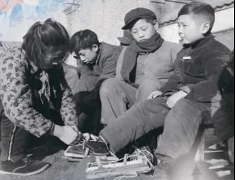上世紀(jì)50年代，孩子們?cè)诖┠景灞?圖源：北京日?qǐng)?bào))