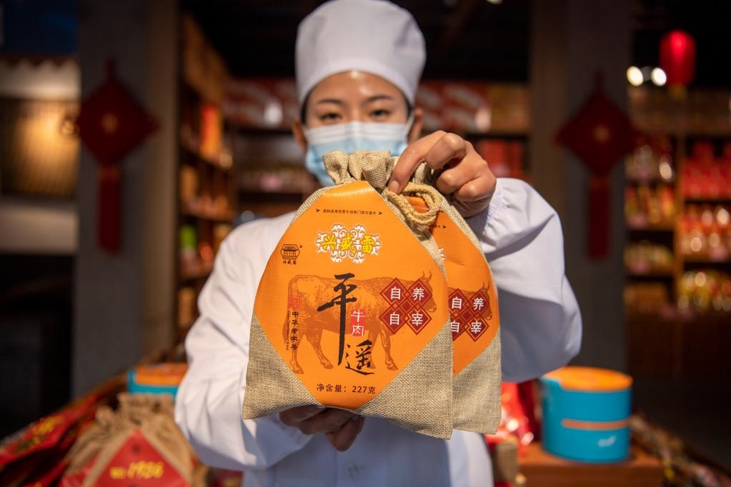 1月27日，在平遙古城南大街的一家平遙牛肉店內，工作人員展示一款牛肉產品。新華社記者 楊晨光 攝