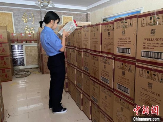 資料圖為檢察人員核對查獲的假冒品牌白酒。青海省人民檢察院供圖