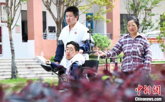 碰上天氣好，朱金祥就會利用休息時間，和鐘華強(qiáng)母親將其推出來賞賞花，曬曬太陽，呼吸一下外面的新鮮空氣。 卓忠偉 攝