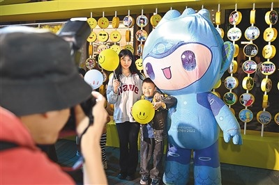 5月7日，在浙江省杭州市湖濱步行街“3D笑臉墻”前，攝影師為游客與杭州亞運會吉祥物之一“宸宸”拍攝合影。