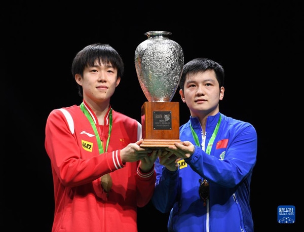 5月27日，樊振東（右）/王楚欽在頒獎(jiǎng)儀式上高舉獎(jiǎng)杯慶祝。當(dāng)日，在南非德班進(jìn)行的2023年世界乒乓球錦標(biāo)賽男雙決賽中，中國(guó)組合樊振東/王楚欽以3比0戰(zhàn)勝韓國(guó)組合張禹珍/林鐘勛，奪得冠軍。新華社記者 李亞輝攝