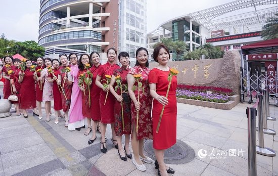 6月7日一早，廈門雙十中學考生家長們身穿旗袍，手拿向日葵在考場外為孩子加油打氣，寓意“旗開得勝，一舉奪魁”。人民網(wǎng)記者 陳博攝