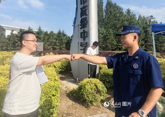 6月7日，遼寧營口老邊區(qū)消防救援大隊的消防員為高考學子加油助威。人民網(wǎng)記者 尹柏寒攝