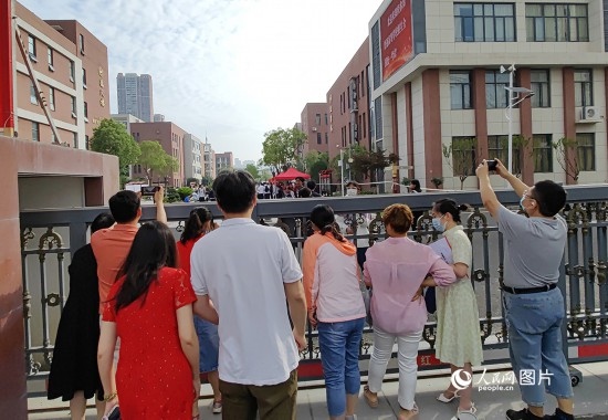 6月7日，武漢市第三中學考點，考生進場后，家長在柵欄外用手機拍攝自己的孩子。人民網(wǎng)記者 郭婷婷攝