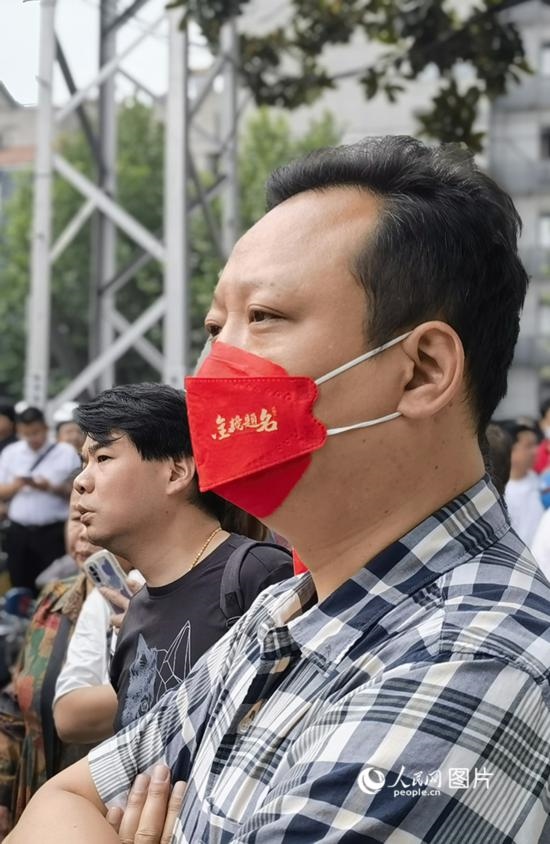 6月7日早，在武漢市第二十六中學考點外，送考家長戴著印有“金榜題名”的口罩。人民網(wǎng) 周雯攝