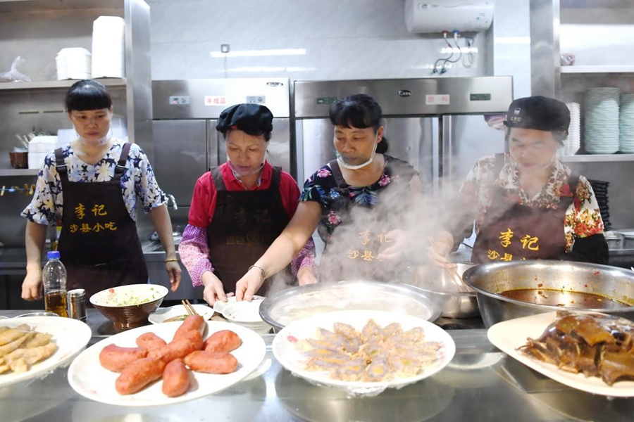 福建三明市沙縣區(qū)一家小吃店工作人員在為客人準(zhǔn)備特色小吃。 新華社記者 林善傳 攝