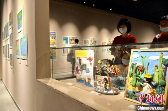 圖為家長(zhǎng)帶著孩子參觀(guān)展覽。呂明 攝