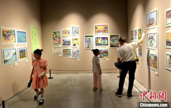 圖為家長(zhǎng)帶著孩子參觀(guān)展覽。呂明 攝