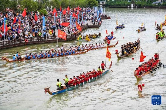 6月23日，在貴州省黔東南苗族侗族自治州施秉縣舉行的獨(dú)木龍舟節(jié)上，獨(dú)木龍舟進(jìn)行水上巡游。