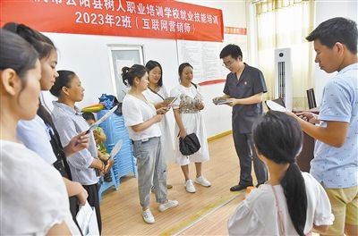  圖③：法院干警現(xiàn)場指導(dǎo)鄉(xiāng)村“代理家長”如何正確管護留守兒童。