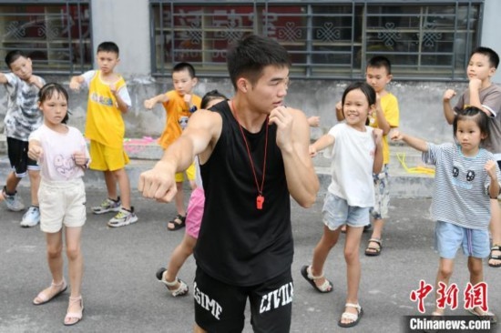 圖為大學(xué)生志愿者在組織孩子們參加體育健身活動(dòng)。廖光福 攝