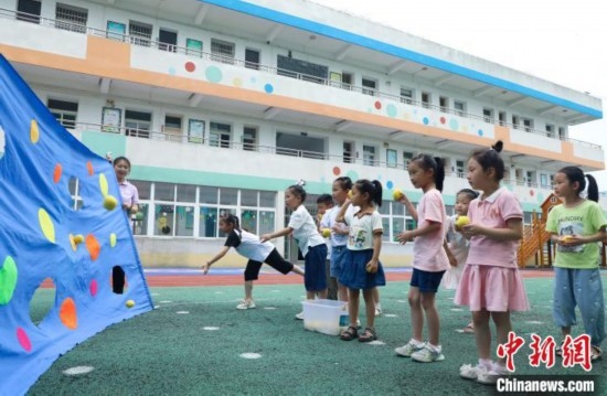 在肥西縣山南鎮(zhèn)中心幼兒園，孩子們在玩布洞投球游戲。陳家樂 攝