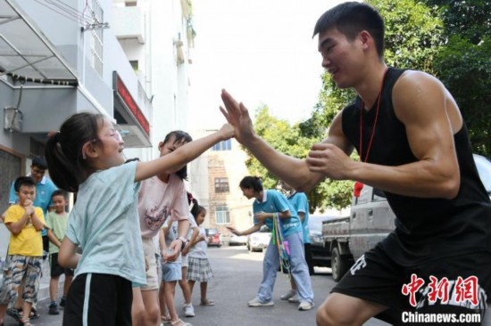 圖為大學(xué)生志愿者在組織孩子們參加體育健身活動(dòng)。廖光福 攝