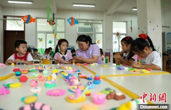 在肥西縣山南鎮(zhèn)中心幼兒園，孩子們在老師的指導(dǎo)下做彩色泥塑。陳家樂 攝
