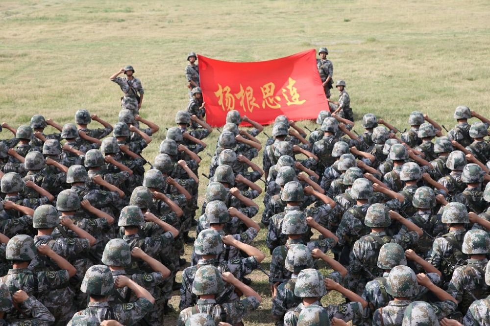 ↑“楊根思連”官兵執(zhí)行任務(wù)前向連旗宣誓（資料照片）。新華社發(fā)