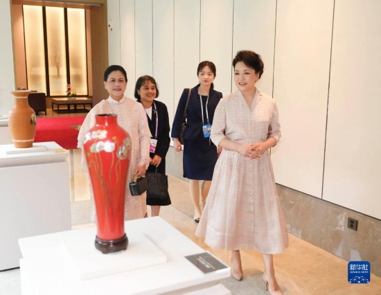 7月27日下午，國(guó)家主席習(xí)近平夫人彭麗媛在四川成都會(huì)見(jiàn)陪同印度尼西亞總統(tǒng)佐科來(lái)華出席第31屆世界大學(xué)生夏季運(yùn)動(dòng)會(huì)開(kāi)幕式并訪華的總統(tǒng)夫人伊莉亞娜。這是彭麗媛和伊莉亞娜欣賞成都特色非遺工藝品。新華社記者 丁林 攝