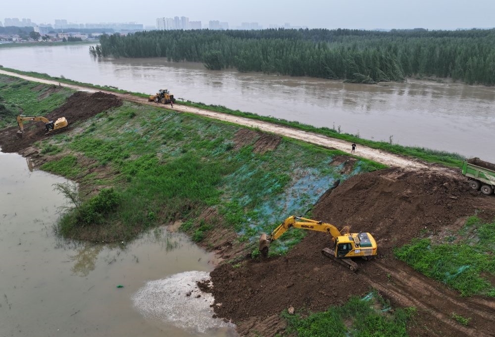 工人操作機(jī)械在白溝河左堤白溝新城高橋村段進(jìn)行除險加固作業(yè)（8月4日攝，無人機(jī)照片）。新華社記者 朱旭東 攝