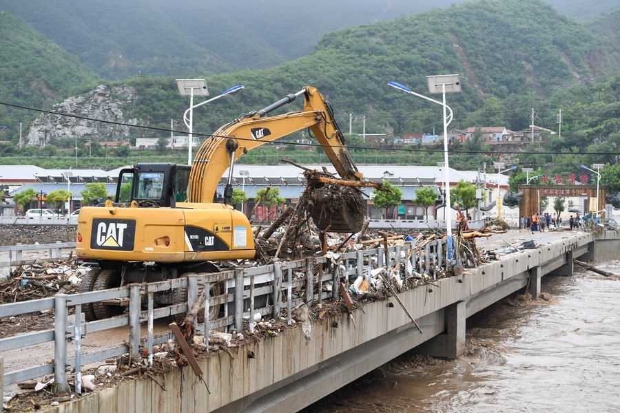 8月1日，在北京市門頭溝區(qū)水峪嘴村村口，一臺挖掘機在清理阻斷橋梁交通的雜物。目前該條道路已經(jīng)疏通完成。新華社記者 鞠煥宗 攝