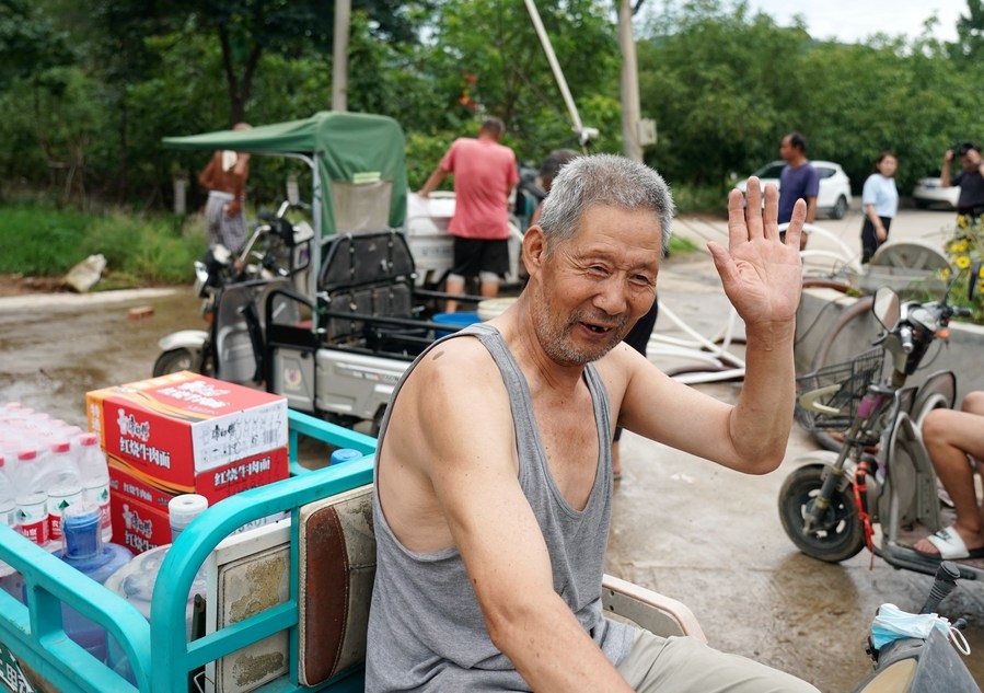 8月5日，從安置點回來的北京市房山區(qū)青龍湖鎮(zhèn)口頭村村民高大爺領(lǐng)到生活物資準(zhǔn)備回家。新華社記者 張晨霖 攝