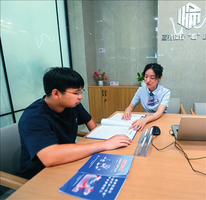 在杭州市臨安區(qū)政務(wù)服務(wù)中心的“為企服務(wù)中心”，黨員志愿者（右）解答企業(yè)主的疑問（2023年7月7日攝）。徐昱攝/本刊