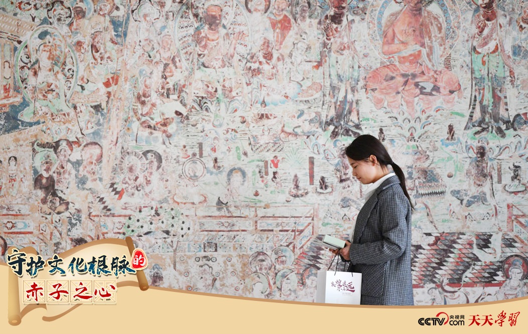 2023年4月25日，敦煌研究院文物數(shù)字化保護(hù)團(tuán)隊(duì)創(chuàng)意營(yíng)銷人員廖雪婷從一幅高保真復(fù)制壁畫(huà)前走過(guò)。