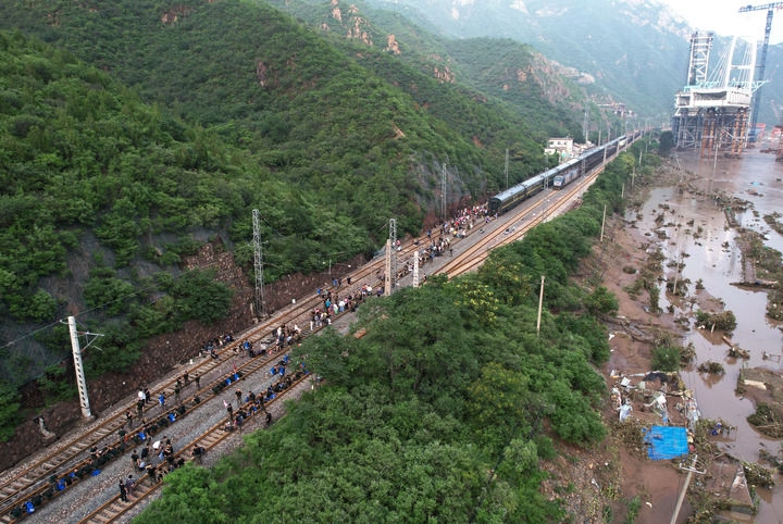 8月2日，受困列車旅客在救援人員幫助下徒步趕往轉(zhuǎn)運客車（無人機照片）。新華社記者 張晨霖 攝