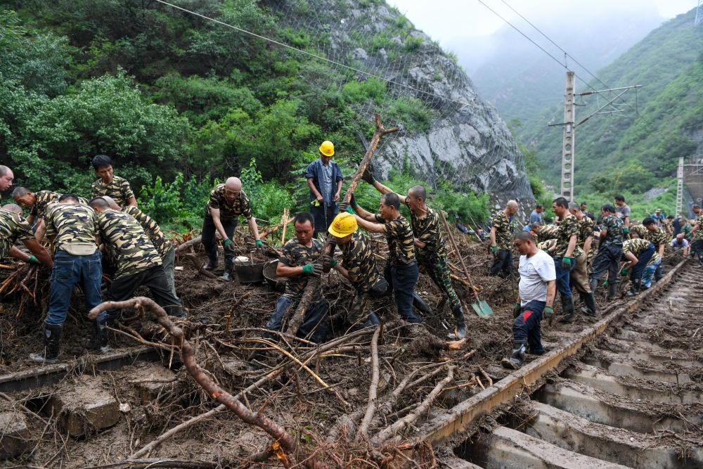8月1日，在北京市門頭溝區(qū)水峪嘴村附近一段被阻斷的鐵路線上，中鐵六局工作人員在清理軌道上的雜物，全力恢復(fù)交通。新華社記者 鞠煥宗 攝