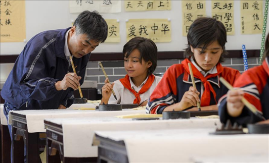 △新疆疏附縣托克扎克鎮(zhèn)中心小學書法教室內(nèi)，同學們正在學習寫毛筆字。
