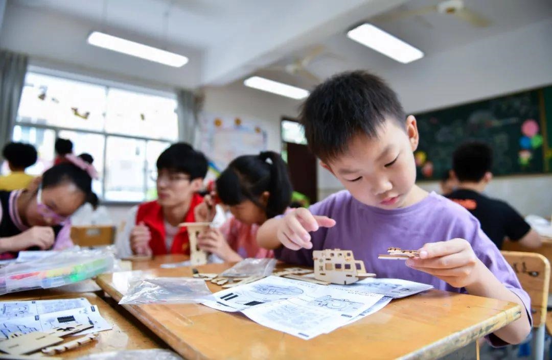 △今年7月，在浙江余姚市舜北小學暑托班內(nèi)，孩子們制作太陽能科學實驗裝置。