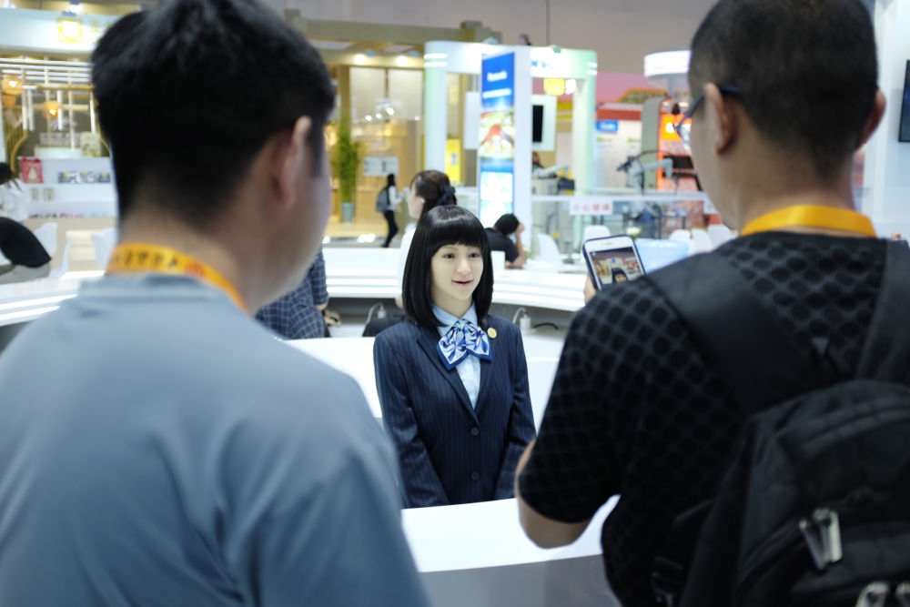 9月1日，媒體記者在國家會議中心與服務(wù)機器人互動。新華社記者 劉夢琪 攝