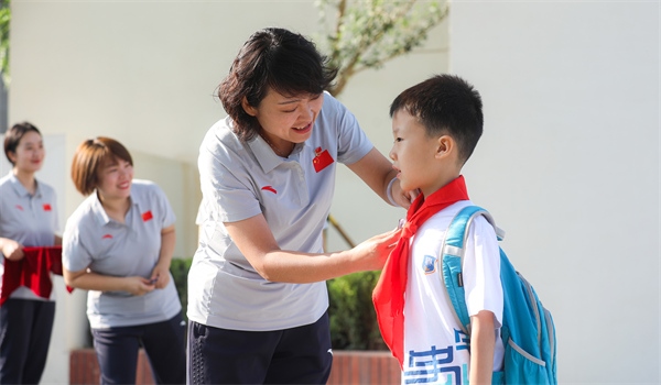 8月30日，雄安史家胡同小學學生體驗學校生活。老師為學生佩戴校徽。