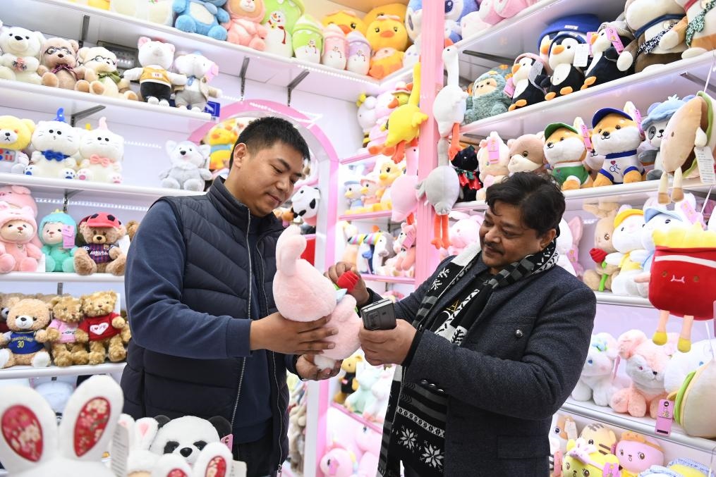 2023年2月2日，來自印度的客商（右）在義烏國際商貿(mào)城的一家玩具店鋪內(nèi)選購商品。新華社記者 黃宗治 攝