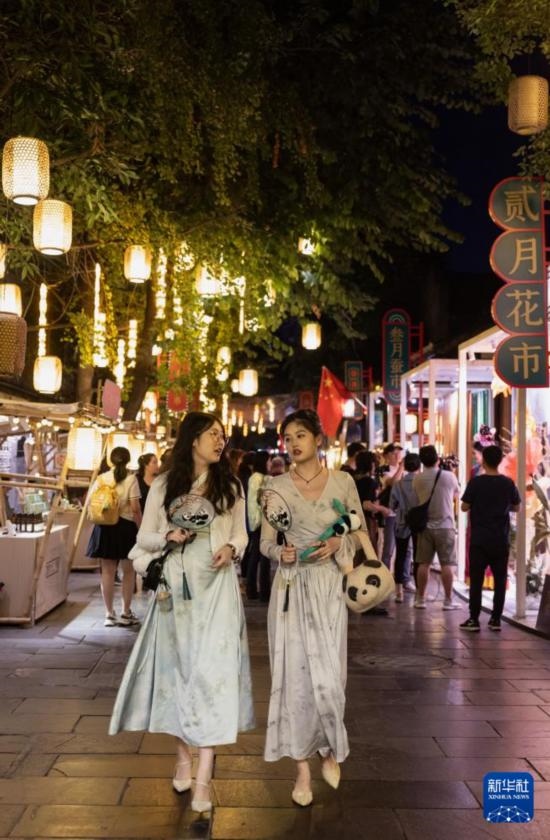 在成都寬窄巷子，兩位來(lái)自安徽的游客在新“十二月市”街區(qū)游覽（9月29日攝）。