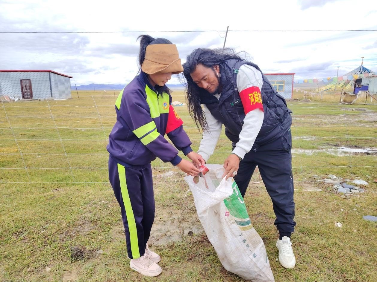 玉樹州稱多縣珍秦鎮(zhèn)河湖志愿者才培和他女兒更求拉毛在清掃垃圾。受訪者供圖