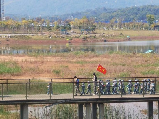 10月24日，秋游的幼兒園小朋友在老師帶領(lǐng)下走在清水塘公園里的木橋上。本報(bào)記者 常雯宜攝