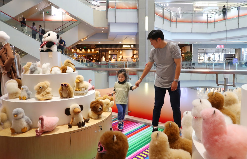 2023年11月2日，顧客在溫暖駝品牌專柜內(nèi)選購。連續(xù)六年參加進(jìn)博會(huì)的秘魯羊駝制品品牌溫暖駝在上海市中心商場開設(shè)了專柜。新華社記者 方喆 攝