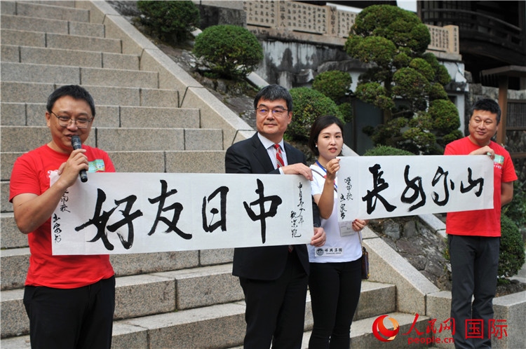 東京中國文化中心主任羅玉泉展示其為本次活動書寫的題詞“中日友好，山高水長”。人民網(wǎng) 蔣曉辰攝