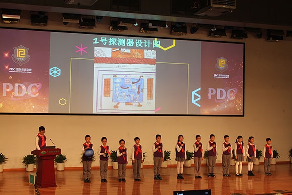 北京呼家樓中心小學(xué)的學(xué)生們展示PDC項(xiàng)目“新行星移民計(jì)劃探索衛(wèi)星設(shè)計(jì)”。