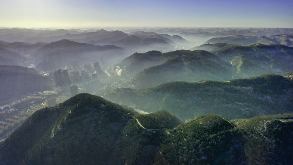 陜西省延安市吳起縣的山山峁峁被茂密的山林覆蓋（2021年12月20日攝，無(wú)人機(jī)照片）。新華社記者 陶明 攝