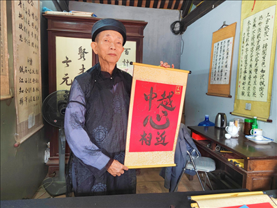 越南首都河內(nèi)文廟內(nèi)，阮明珠展示“中越心相近”書(shū)法作品。