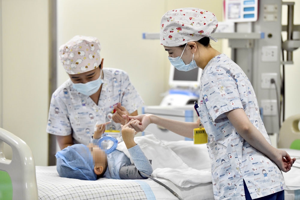在山東省棗莊市婦幼保健院兒童ICU病房，醫(yī)護(hù)人員為完成靶向治療藥物諾西那生鈉的4歲脊髓性肌萎縮癥患兒加油鼓勁（2022年1月1日攝）。諾西那生鈉注射液是我國首個獲批治療脊髓性肌萎縮癥的進(jìn)口藥物，2019年進(jìn)入中國市場時，每針價格近70萬元。在2021年國家醫(yī)保目錄藥品談判中，以3.3萬元每針的價格進(jìn)入新版醫(yī)保藥品目錄。新華社記者 郭緒雷 攝