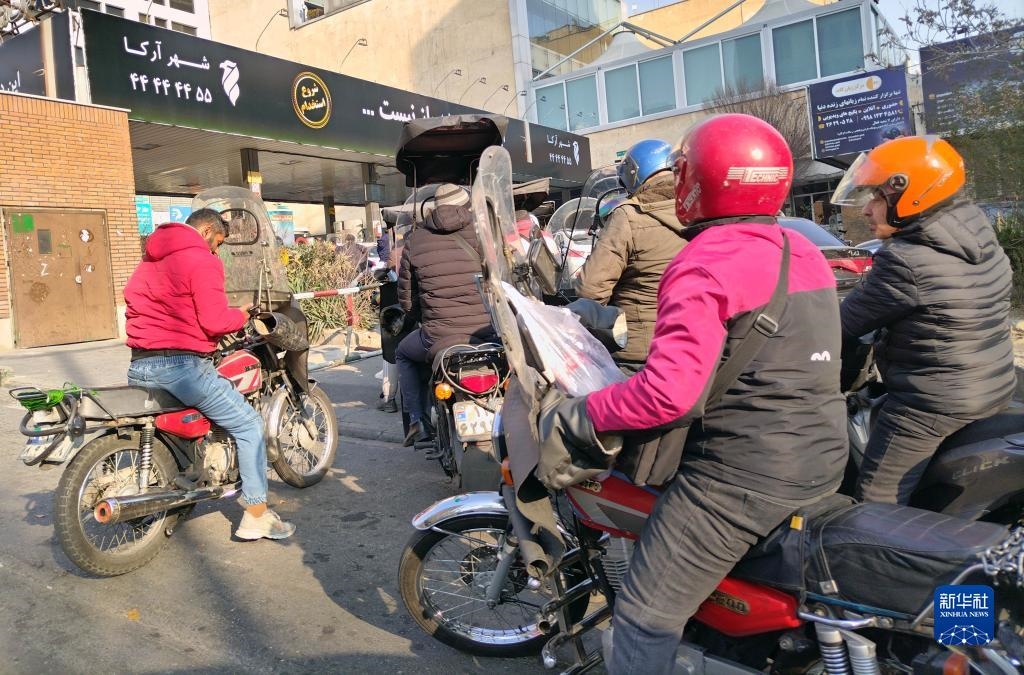 12月18日，摩托車在伊朗首都德黑蘭的一家加油站外等待加油。新華社記者 沙達(dá)提 攝