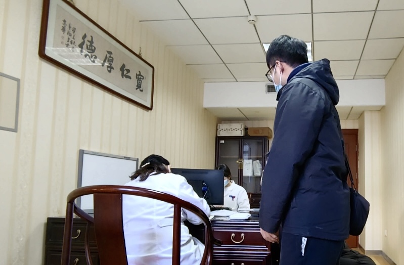 陪診師大飛陪同來(lái)京就診的患者在醫(yī)院?jiǎn)栐\。人民網(wǎng)記者 任妍攝