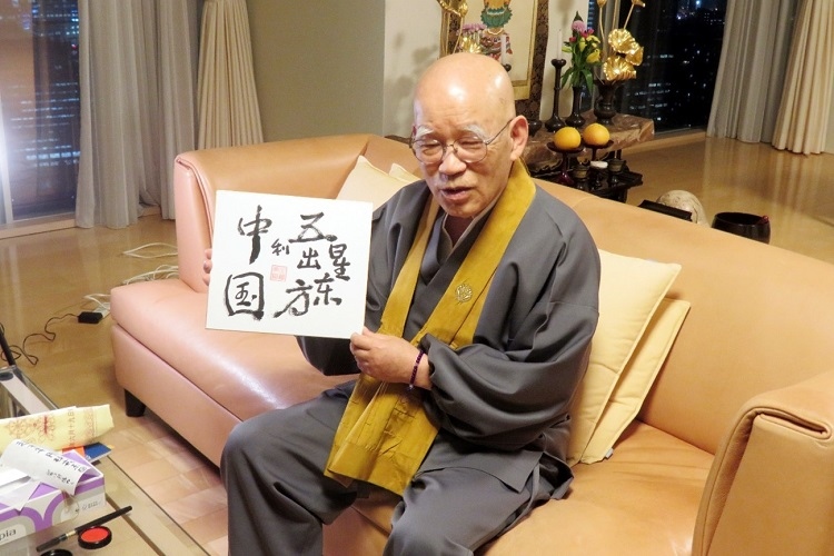小島康譽展示自己書寫的“五星出東方利中國”。視頻截圖