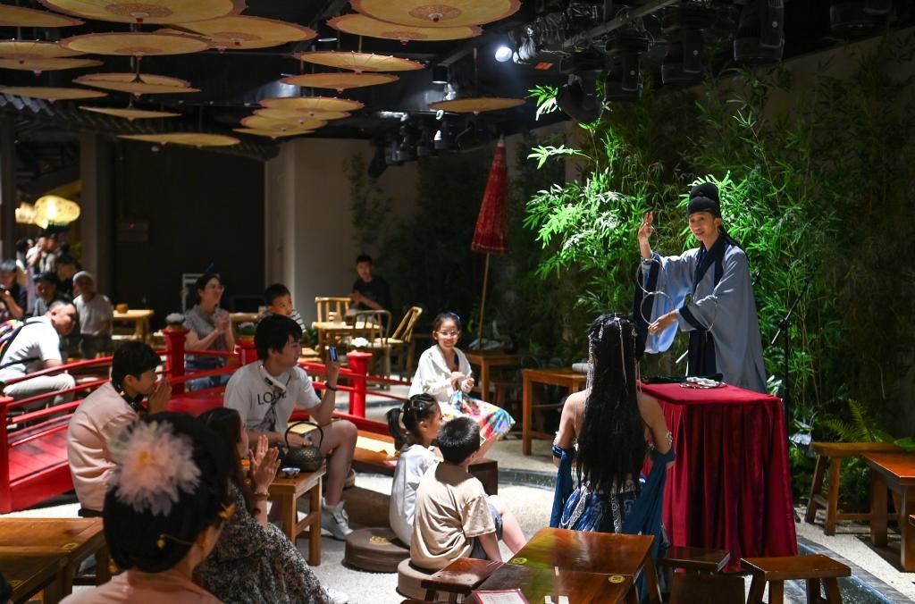 游客在長安十二時辰主題街區(qū)觀看唐風(fēng)演藝《大唐曲藝》。新華社記者鄒競一 攝