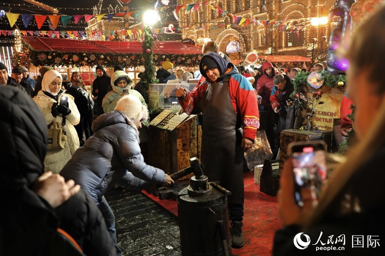 游客在新年集市上體驗制作紀念幣。人民網(wǎng)記者 隋鑫攝